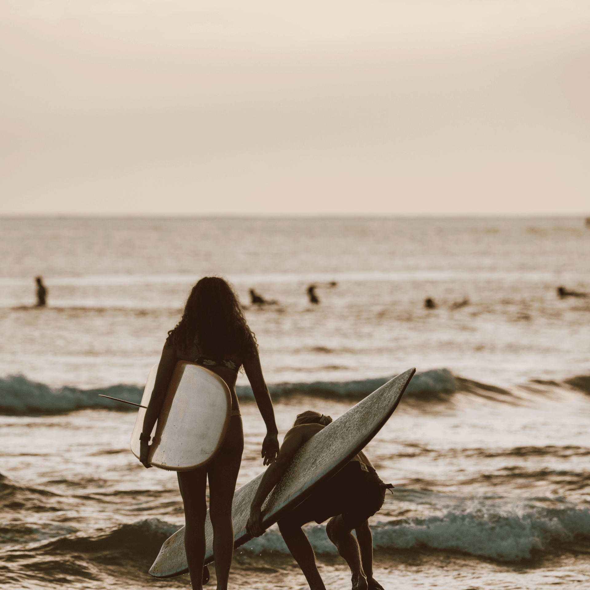 Jeune femme avec planche de surf sur la plage, témoignage séjour solo Lovebus