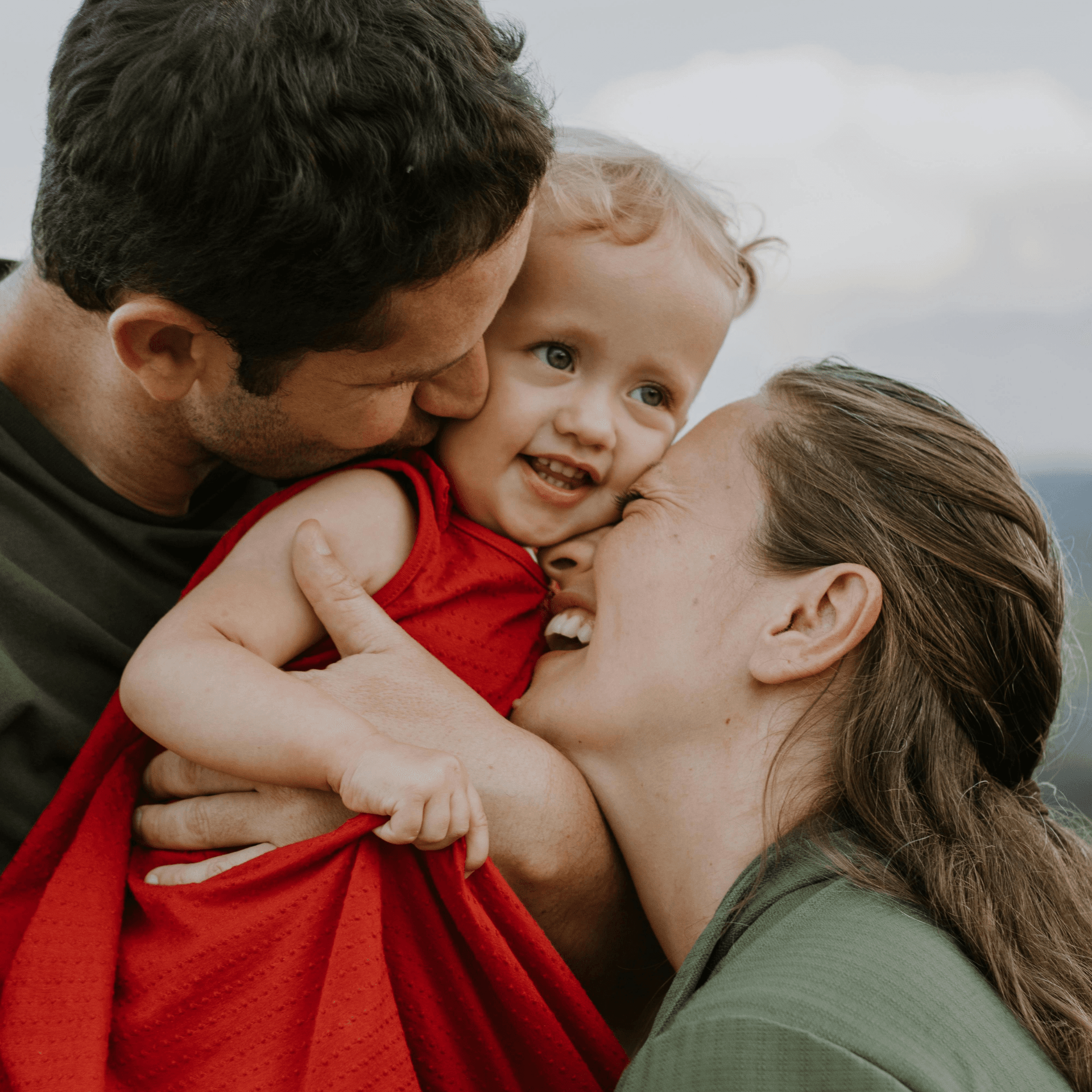 Famille souriante avec jeune enfant devant le love bus aménagé, vacances insolites