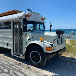 Lovebus aménagé stationné sur une plage avec vue mer, hébergement insolite Atypik Home