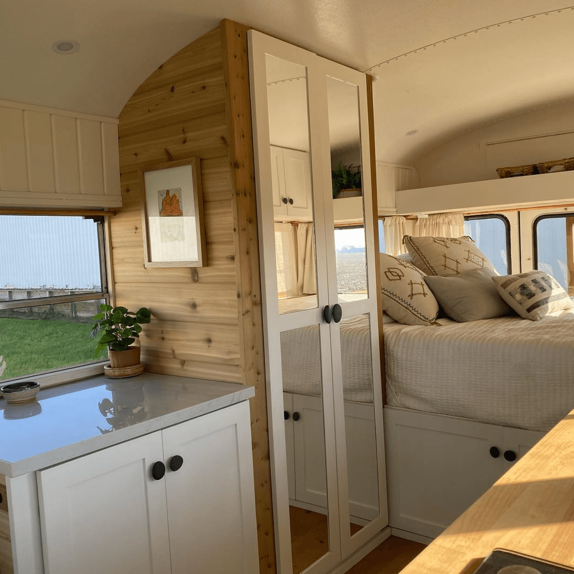 Lit double confortable dans love bus aménagé, décoration cosy avec vue panoramique
