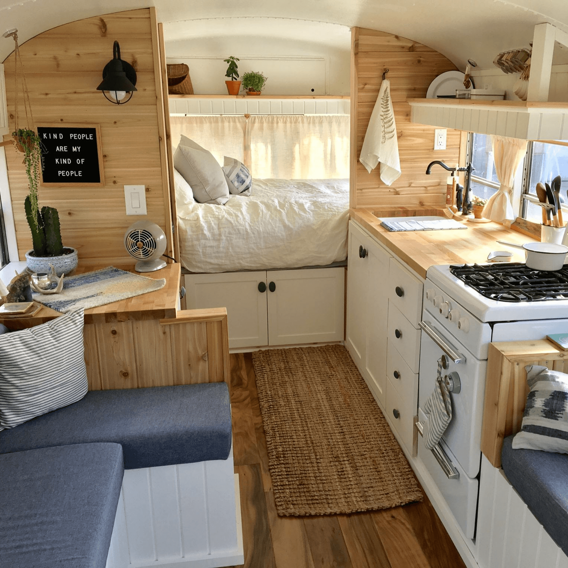 Intérieur spacieux du love bus avec cuisine, coin salon et couchage, décoration style bohème