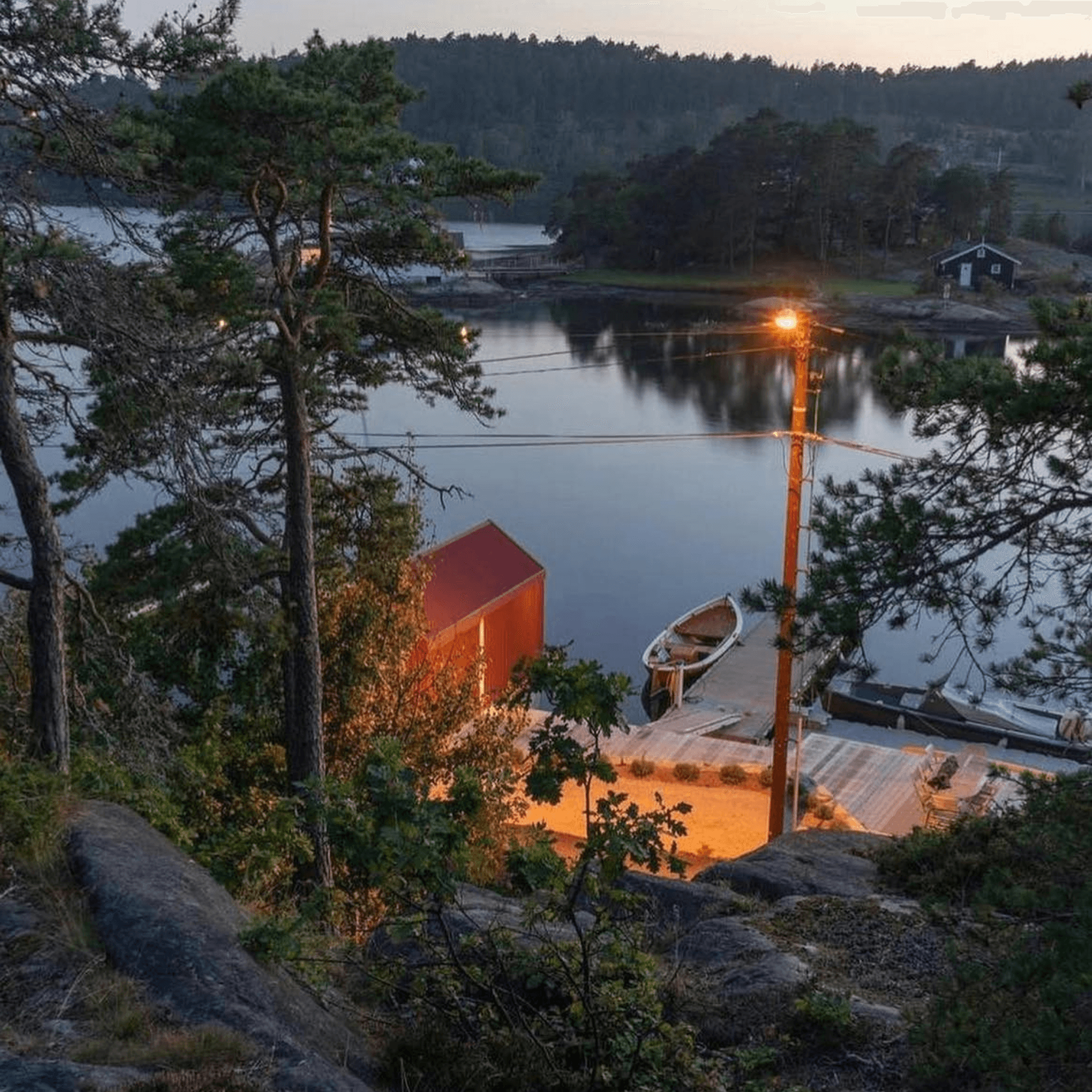 Refuge flottant scandinave éclairé au coucher de soleil, parfait pour une réservation d’escapade romantique.