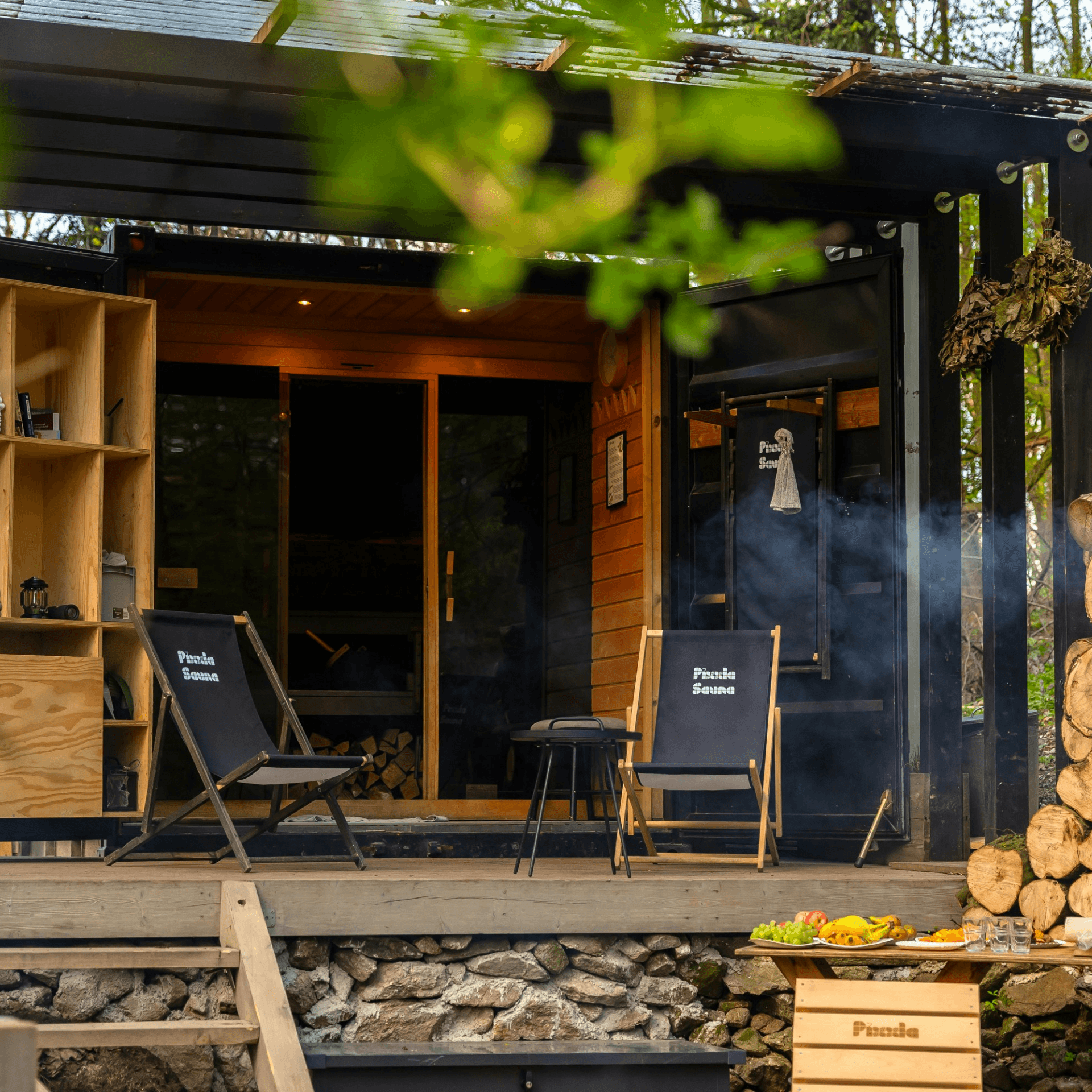 Sauna noir extérieur terrasse bois chaises longues cabane forêt