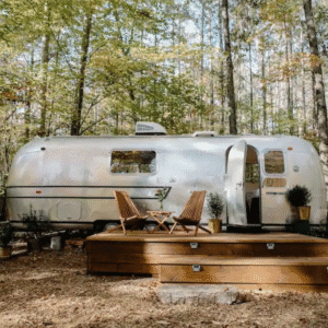 Airstream argenté terrasse bois deux chaises longues forêt verte printemps